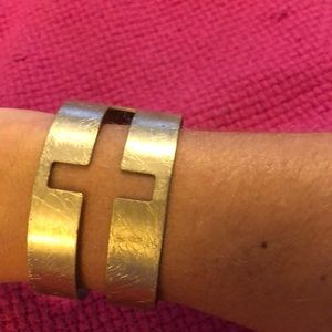 Brushed gold cuff bracelet worn cutout cross